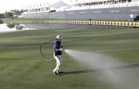 Un empleado riega el green del hoyo 18, luego que la PGA canceló el resto del Players Championship (AP/Lynne Sladky)