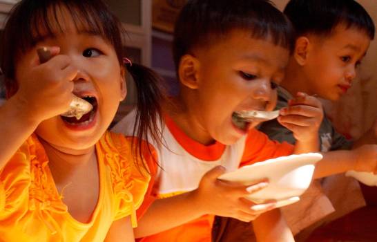 Niños camboyanos infectados por el virus del sida toman su comida en la sede de la ONG MARYKNOLL en Phnom Penh, Camboya.